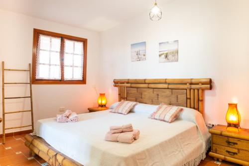 a bedroom with a bed with towels on it at Villa NARE - Casa típica majorera in Villaverde