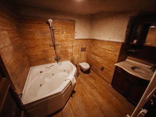 a bathroom with a tub and a toilet and a sink at Asteria Cave Hotel in Goreme