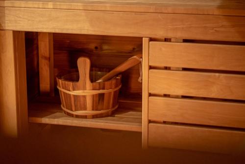 a wooden basket with two wooden utensils in a cabinet at Ég & Föld Borvendégház in Szekszárd