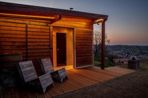 a cabin with two chairs on a wooden deck at Ég & Föld Borvendégház in Szekszárd