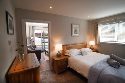 a bedroom with a bed and a desk with two lamps at Scorr House Apartment in Portree