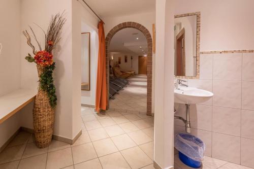 a bathroom with a sink and a vase with flowers at Chalet Central - Top Cc8 in Königsleiten