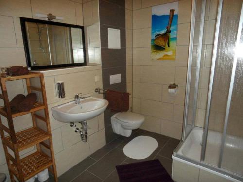 La salle de bains est pourvue d'un lavabo, de toilettes et d'une douche. dans l'établissement Sundappartement, à Stralsund