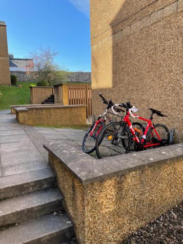 
a bike parked next to a stone wall at Central St Andrews 2 Bed Apartment - Free Parking in St. Andrews
