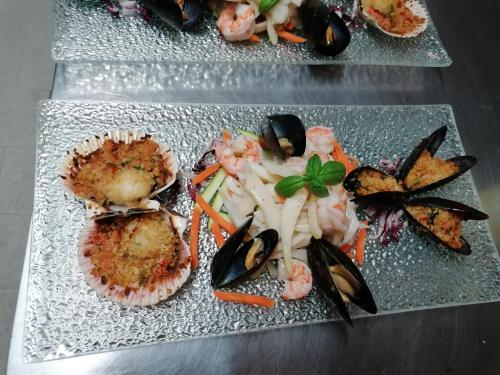 a plate of food with shrimp and vegetables on a table at Hotel Antico Borgo in Riolo Terme