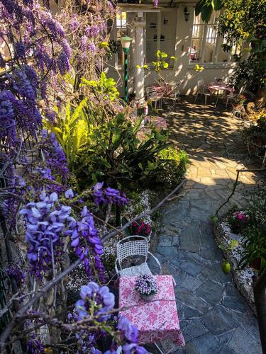a garden with purple flowers and a bench at Hotel Villa La Brise in Sanremo
