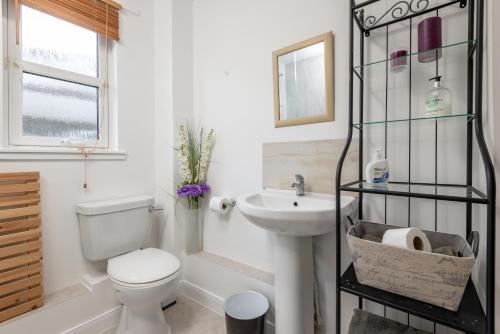 a white bathroom with a toilet and a sink at 2 Bedroom Apartment in a Quiet Neighbourhood in St. Andrews