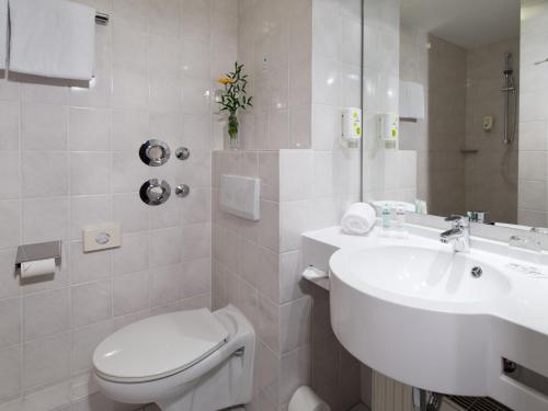 Baño blanco con lavabo y aseo en ACHAT Hotel Darmstadt Griesheim en Darmstadt