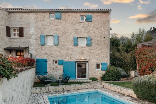 a villa with a swimming pool in front of a building at Villa Filipa in Brkač