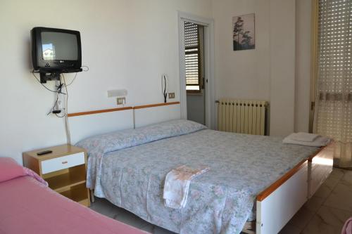 una camera con due letti e una TV a parete di Hotel Elvira a Rimini