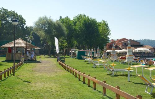 a park with chairs and tables and umbrellas at Hotel La Bella Venere in Caprarola