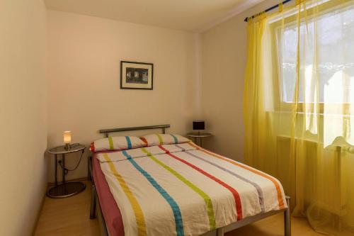 una piccola camera da letto con un letto e una finestra di Ferienwohnung Alina a Singen