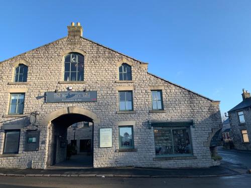 an old brick building with an archway on a street at The Merchant's Yard in Tideswell