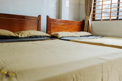 two beds sitting next to each other in a bedroom at SH Hotel in Hue