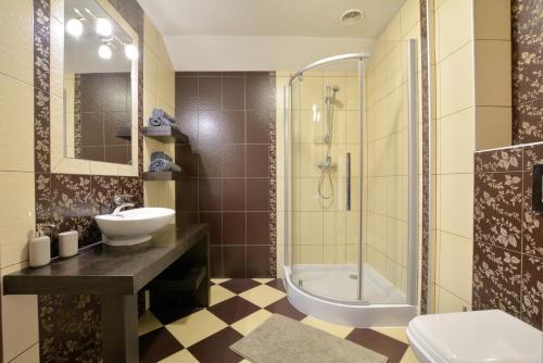 a bathroom with a sink and a shower and a toilet at Apartamenty EverySky Gasthaus Karpacz in Karpacz