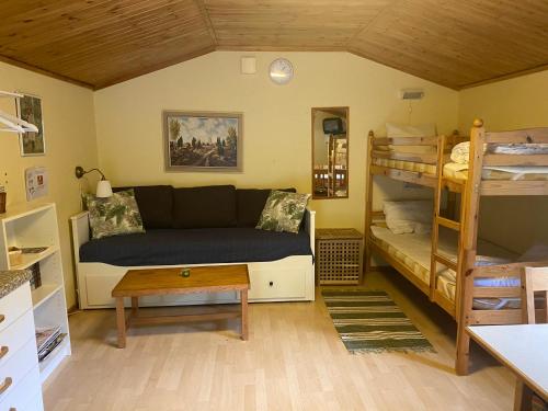 ein Wohnzimmer mit einem Sofa und Etagenbetten in der Unterkunft Ullstorps Stugor in Höör