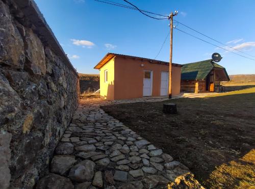 eine Steinmauer mit einem Gebäude im Hintergrund in der Unterkunft Brvnara Krin 2 in Nova Varoš