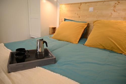 a bed with a tray with a coffee pot on it at Le Moutardier : chaleureux T2 au coeur de ville in Dijon