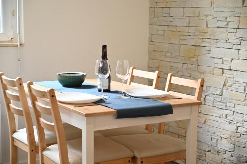 - une table à manger avec une bouteille de vin et des verres dans l'établissement Le Moutardier : chaleureux T2 au coeur de ville, à Dijon