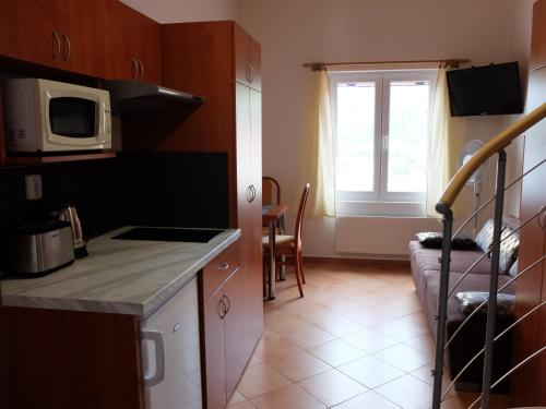 a small kitchen with a microwave and a window at Apartments Sunce in Brna