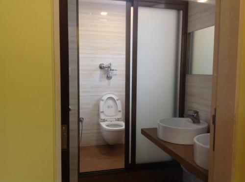 a bathroom with a toilet and a sink at Pals Hotel in Mumbai