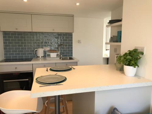 a kitchen with a table with two plates on it at Close Quarters in Newton Ferrers