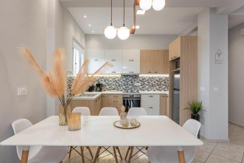 a white kitchen with a white table and chairs at JT Apartments in Kissamos