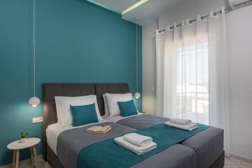 a bedroom with a large bed with blue walls at JT Apartments in Kissamos