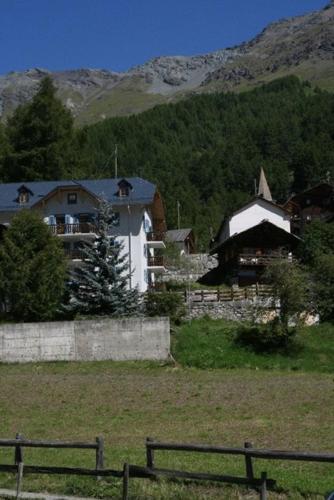 a farm with a house and a fence in a field at Hotel de la Sage in La Sage