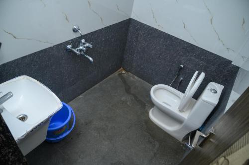 a bathroom with a toilet and a sink at Glucklich Beach Cottages in Kundapur