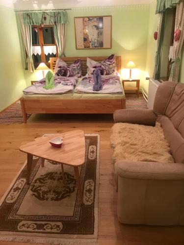 ein Wohnzimmer mit einem Bett und einem Sofa in der Unterkunft Alte Schule Weichselboden in Weichselboden