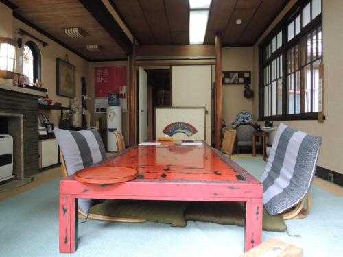 a red table in a room with two chairs at Tsubakiso in Nara