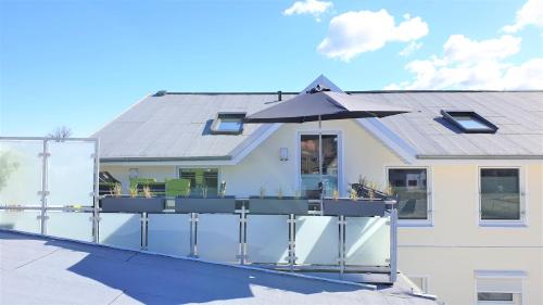a house with an outdoor deck with an umbrella at Urlaubsdomizil InselLust-Rügen in Sassnitz