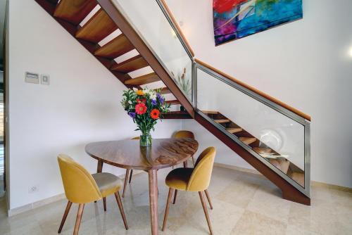 a dining room with a table and chairs with a vase of flowers at Ribera del Marlin - Sotogrande in Sotogrande