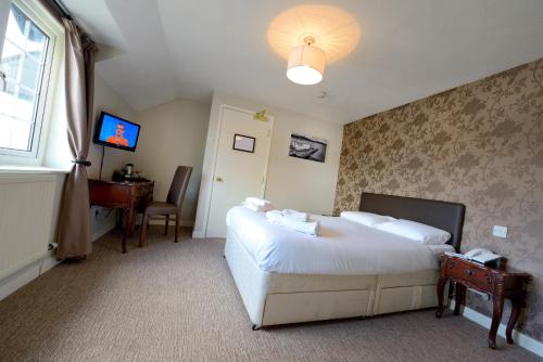 A bed or beds in a room at The Savoy Country Inn 