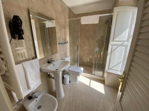 a bathroom with a sink and a toilet and a shower at HOSTERÍA SEÑORÍO DE BIZKAIA in Bakio