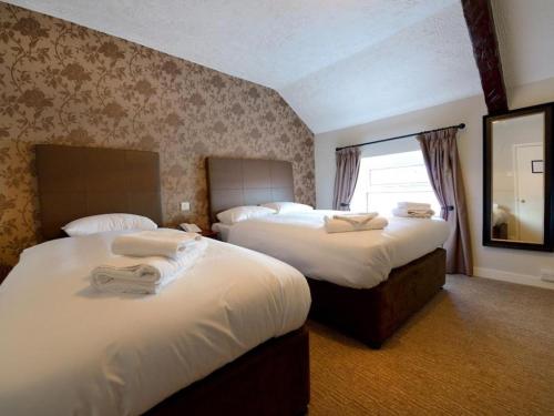 a hotel room with two beds and a mirror at Savoy Country Inn in St Clears