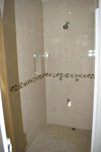 Łazienka z prysznicem i podłogą wyłożoną kafelkami w obiekcie Hotel D’Cural w mieście Oxkutzcab