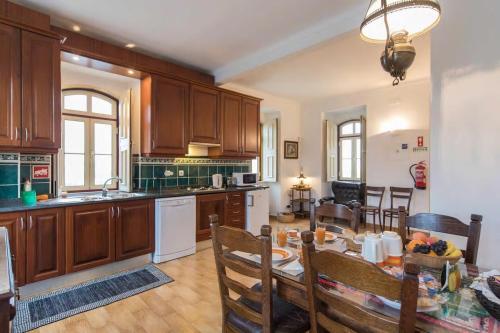 a kitchen with wooden cabinets and a table in a room at Quinta do Americano in Sardoal