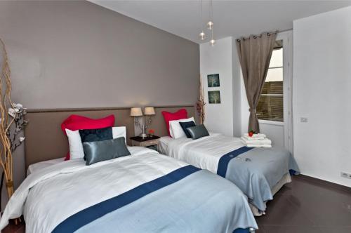 une chambre avec deux lits et une fenêtre dans l'établissement Sunlight Properties - AmourViolette - Central apartment w RARE terrace, à Nice