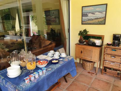 a blue table with bowls of food on it at On Pinewood Guest House in Cape Town