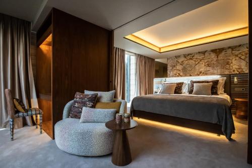 a hotel room with a bed and a chair at Vinha Boutique Hotel - The Leading Hotels of the World in Vila Nova de Gaia
