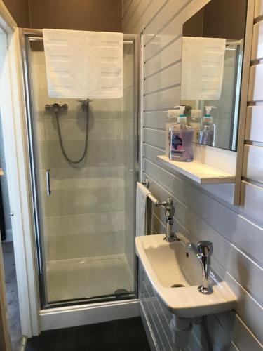 uma casa de banho com um chuveiro e um lavatório. em Brunton House Guest House em Clacton-on-Sea