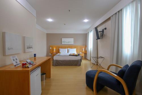 a hotel room with a bed and a desk at Belo Horizonte Plaza in Belo Horizonte