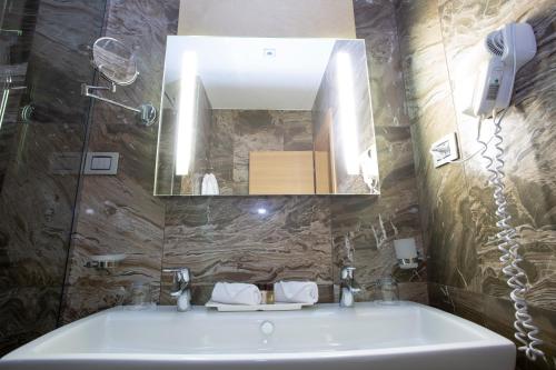 a bathroom with a sink and a mirror at Best Western Premier Ark Hotel in Tirana