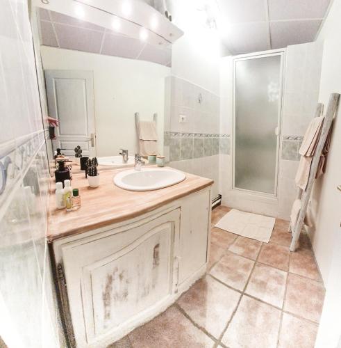 une salle de bain blanche avec un lavabo et une douche dans l'établissement L'Auberge, à Saint-Vincent-les-Forts