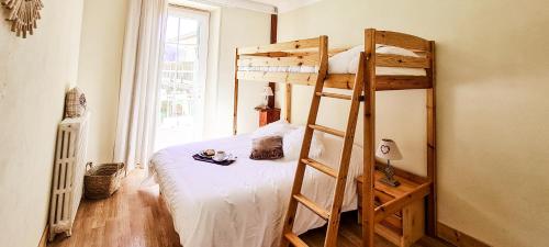a bedroom with a bunk bed with a ladder at L'Auberge in Saint-Vincent-les-Forts