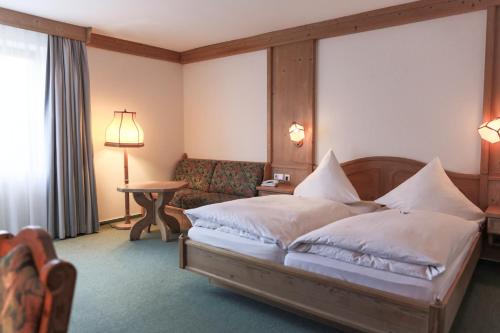 a hotel room with a bed and a couch at AKZENT Hotel Thiemann in Ganderkesee