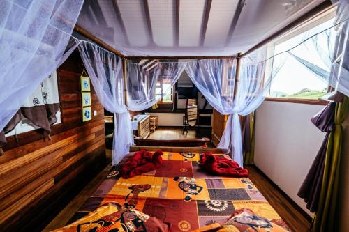 ein Schlafzimmer mit einem Bett in einem Zimmer mit Vorhängen in der Unterkunft Bed and breakfast Riviere in Le Marin