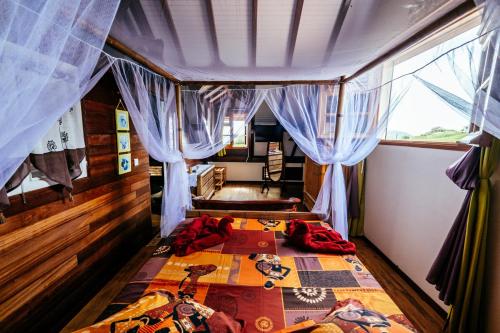 a bedroom with a bed in a room with curtains at Bed and breakfast Riviere in Le Marin